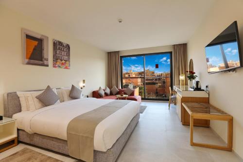 ein Schlafzimmer mit einem großen Bett und ein Wohnzimmer in der Unterkunft Ari Boutique Hôtel - Adult Only in Marrakesch