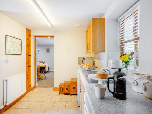 a kitchen with white walls and a counter top at Coed Y Gaer Annexe - Uk43776 in Llansilin