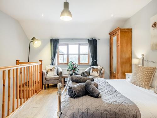 a bedroom with a large bed and a staircase at Coed Y Gaer Annexe - Uk43776 in Llansilin
