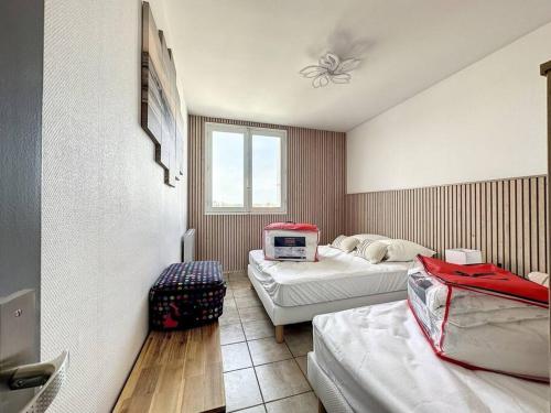 una habitación de hotel con 2 camas y un monitor de ordenador en la pared en Bord de mer vue panoramique avec parking privé en Saint-Jean-de-Monts