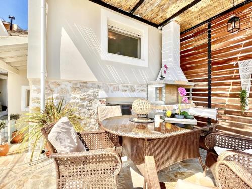 un patio con tavolo, sedie e camino di Dimitris Luxury Cottage with private pool by DadoVillas a Kalámi