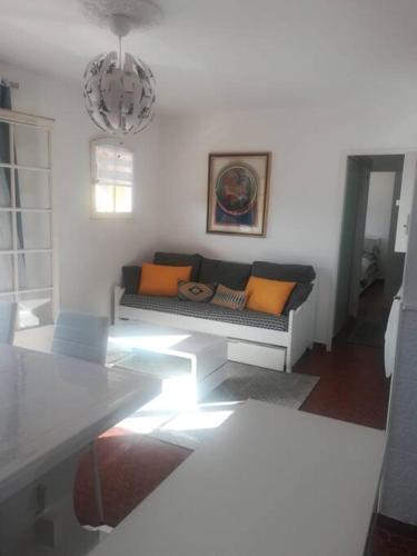 un salon avec un canapé avec des coussins orange dans l'établissement apartment, swimming pool, tennis, parking, à La Croix-Valmer