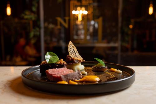 a black plate of food on a table at No11 Boutique Hotel & Brasserie in Edinburgh