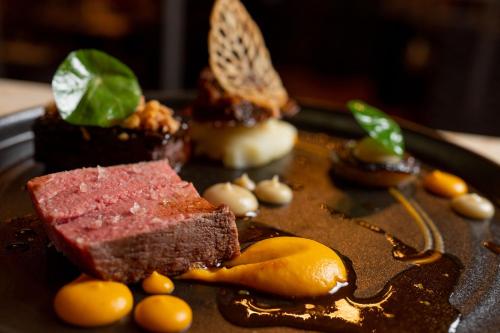 a plate of food with a piece of cake and butterflies at No11 Boutique Hotel & Brasserie in Edinburgh