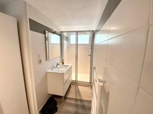 une salle de bains avec un lavabo et un miroir dans l'établissement LES COTTAGES DE LEON, à Léon