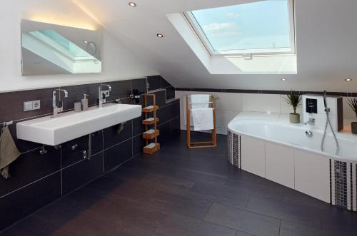 a bathroom with a sink and a tub and a window at ⸨⸩ Sunset Penthouse: Messe - Siemens - DB - MAN ⸨⸩ in Nürnberg