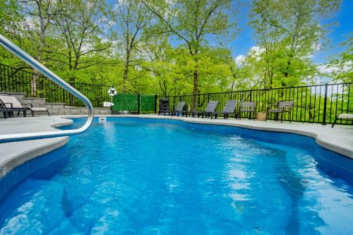 a swimming pool with chairs and a fence at Cedarwood Farmstead in Ridgedale