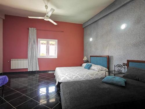Schlafzimmer mit roten Wänden, einem Bett und einem Fenster in der Unterkunft Résidence touristique du chêne vert in Ifrane
