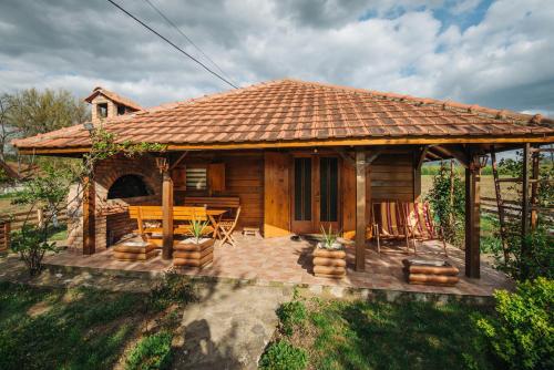 een houten hut met een tafel en stoelen op een terras bij Apartman Dača in Malo Laole