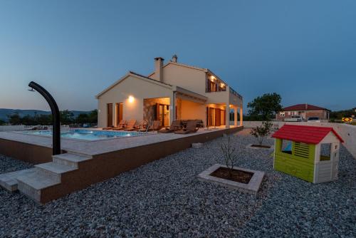 a home with a backyard with a house and a dog house at Vila Vanessa Trogir - Čiovo in Trogir
