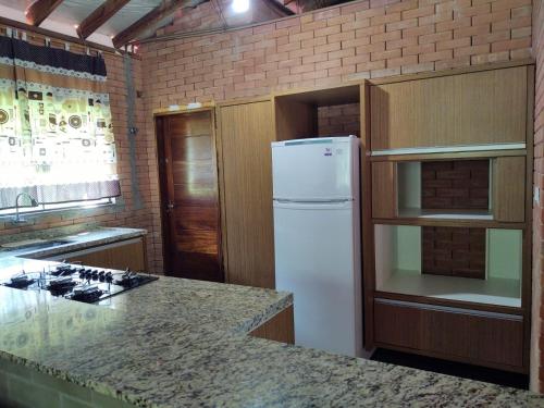 Il comprend une cuisine équipée d'un réfrigérateur blanc et d'un comptoir. dans l'établissement Chácara Buscapé, à Mogi das Cruzes