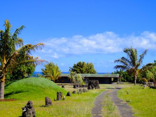 a path in front of a building with palm trees at Heva Eco Lodge in Hanga Roa