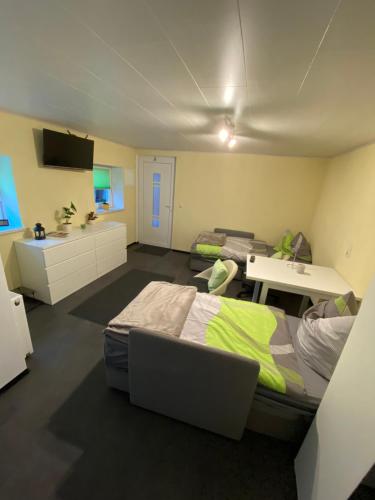1 dormitorio con 2 camas y escritorio con ordenador portátil en Kleines Studio mit Gartenzugang, en Milbitz