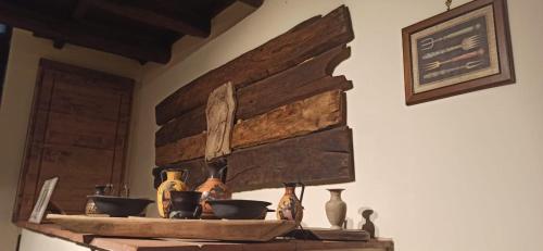 une étagère avec des bols et des vases sur un mur dans l'établissement Convivio Etrusco, à Bassano in Teverina