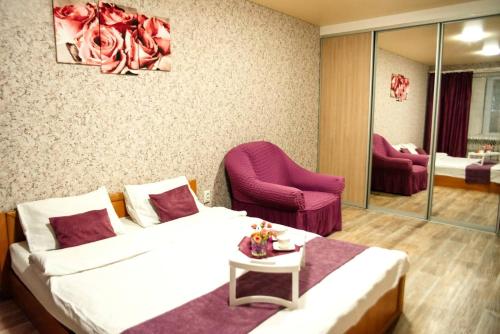 une chambre d'hôtel avec un lit et une chaise dans l'établissement Затишна квартира в центрі, ближче до Софіївського парку., à Ouman