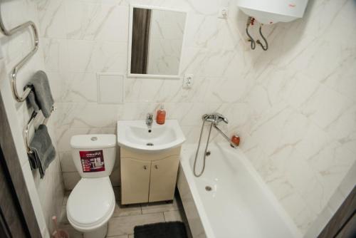 La salle de bains est pourvue de toilettes, d'un lavabo et d'une baignoire. dans l'établissement Затишна квартира в центрі, ближче до Софіївського парку., à Ouman