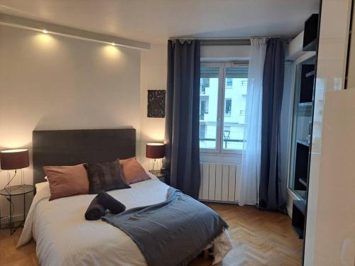 a bedroom with a bed and a large window at Appartement aux Portes de Paris et 5 minutes du métro in Charenton-le-Pont