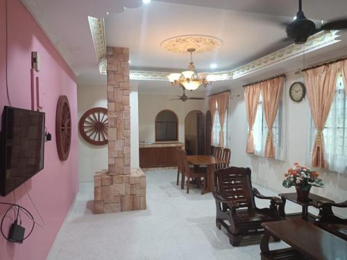 un salon avec une cheminée et une salle à manger dans l'établissement BUTIK VILLA, à Port Dickson
