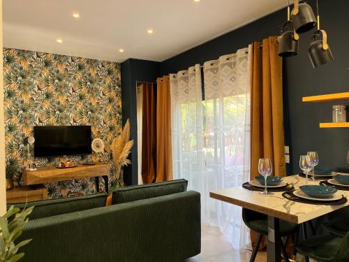a living room with a dining table and a television at O deux Cèdres in Les Arcs sur Argens