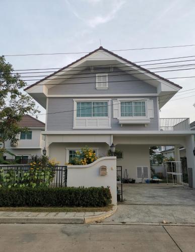 a gray house with a white fence at บ้านพักสุวรรณภูมิ​ แอร์​พอร์ต​ลิงค์​ลาดกระบัง in Ban Khlong Lat Bua Khao