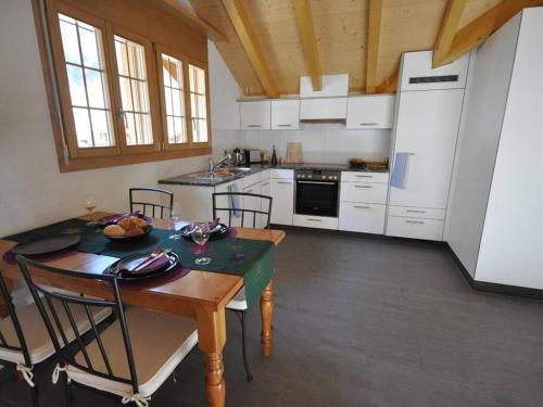 a kitchen with a table and chairs and a kitchen with white appliances at Charming Penthouse in Lauterbrunnen