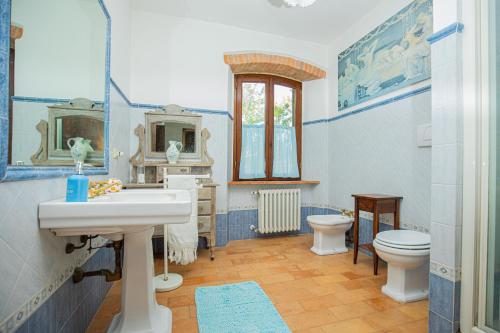 a blue and white bathroom with a sink and a toilet at Affitti Brevi Toscana - Ospitalità in Toscana in Fonteblanda