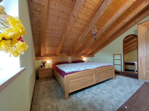 a bedroom with a bed and a wooden ceiling at Ferienwohnung Abendrot in Aßling