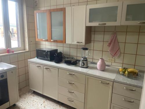 une cuisine avec des armoires blanches et un comptoir avec un mixeur dans l'établissement Casa Amore, à Tarente