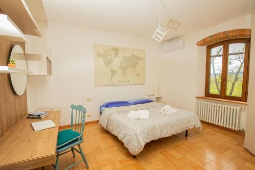 1 dormitorio con cama, escritorio y mesa en Affitti Brevi Toscana - Ospitalità in Toscana, en Fonteblanda