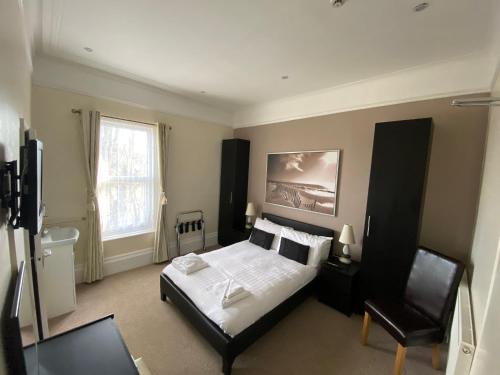1 dormitorio con 1 cama y 1 silla en Somerton Lodge, en Shanklin