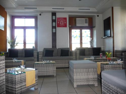 a restaurant with wicker chairs and tables and windows at Gasthof zum Falken in Frauenfeld