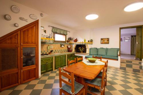 cocina con mesa de madera y armarios verdes en Casa Pein, en Carloforte