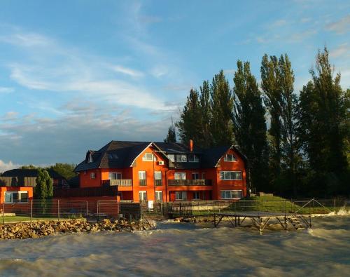 uma grande casa vermelha com uma mesa de piquenique em frente em Rider Beach em Balatonszemes