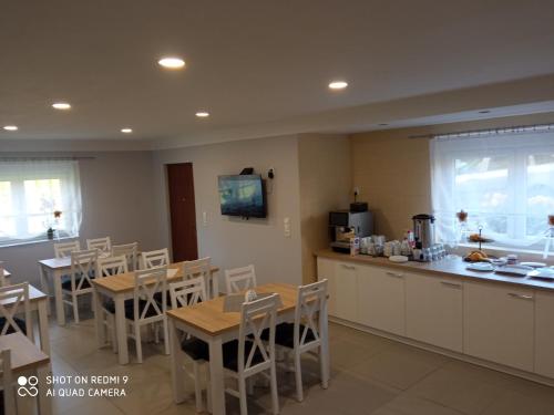 a kitchen and dining room with tables and a counter at Bożenka in Niechorze