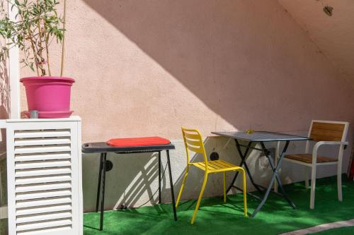 マルセイユにあるLE PETIT NID DES CHUTES LAVIESの- 緑の床の客室内のテーブル2台と椅子