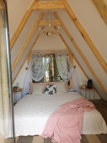 a bedroom with a white bed in a attic at Rock Oak Camping in Imotski