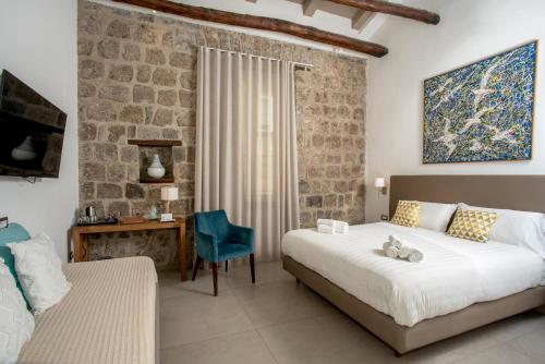 um quarto com 2 camas, uma mesa e uma cadeira em La Chiaja art&relais em Castellammare di Stabia