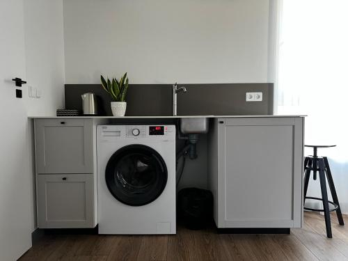 a kitchen with a washing machine and a sink at Tilzes Studio apartaments, Self check-in, Free parking, Comfort in Klaipėda