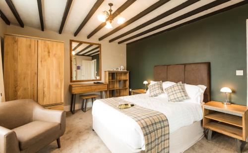 a bedroom with a bed and a chair and a desk at King Arthurs Arms in Tintagel