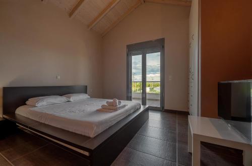 a bedroom with a large bed and a television at Villa Manolia in Preveza