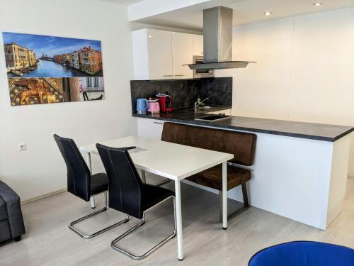 a kitchen with a white table and black chairs at 102 Venedig 59m2, 4-8 Pers extra Bedroom in Klagenfurt