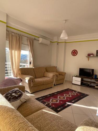 uma sala de estar com dois sofás e uma televisão em Panoramic View Apartment em Përmet