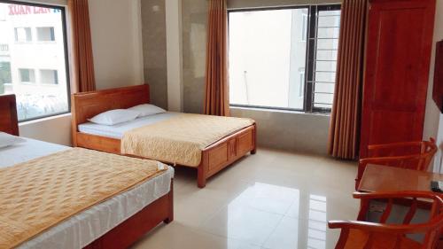 a hotel room with two beds and a window at Hai Hoa Hotel in Cửa Lò