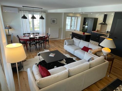 a living room with a white couch and a table at Le Hêtre Rouge & spa in Barr