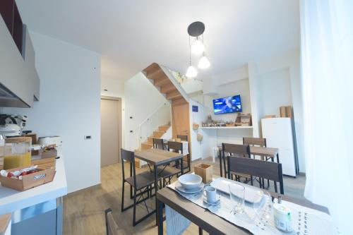 a kitchen and dining room with a table and chairs at Slow Chic Apartment BeB Policlinico in Messina