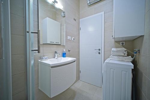 a white bathroom with a sink and a shower at Apartment Toni with spacious terrace in Postira