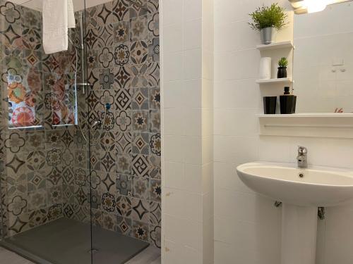 a bathroom with a shower and a sink at window on the lake in Anguillara Sabazia