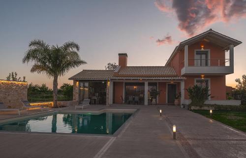 a house with a swimming pool in front of a house at Villa Manolia in Preveza