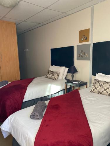 a hotel room with two beds and a red blanket at Straebe Stay in Bloemfontein
