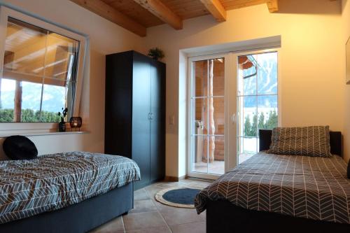 a bedroom with a bed and a sliding glass door at Chalet Giusto in Kötschach